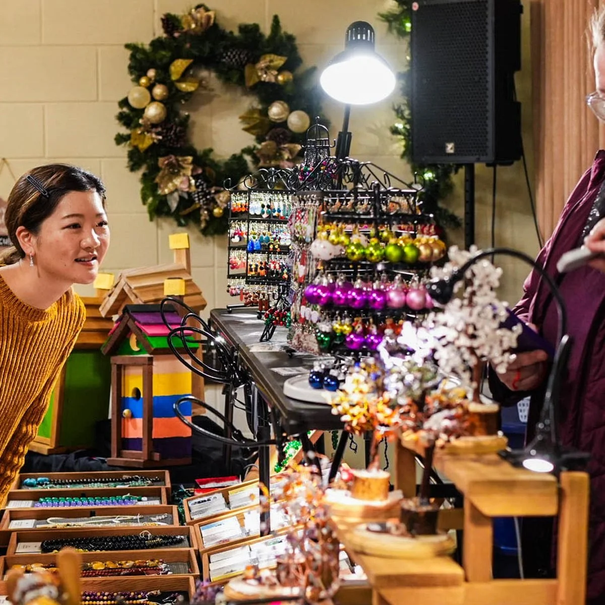 The Bijoux Beads stall at the market, earrings on tiered racks and gemstone trees along the table