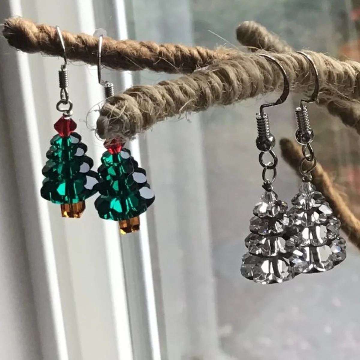 A closer view of two more pairs on a lower branch, one in deep teal crystal and one in clear cut glass