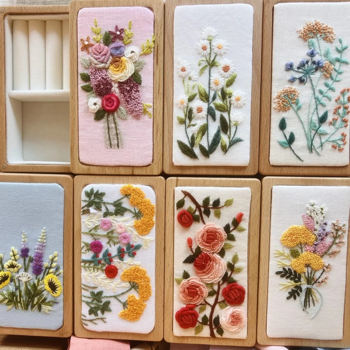 Wooden jewellery boxes with embroidered lids showing daisies, roses, lavender and wildflowers