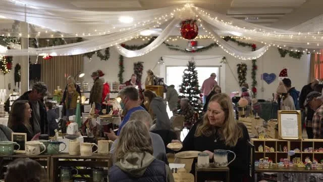A wide view of the decorated hall full of shoppers.