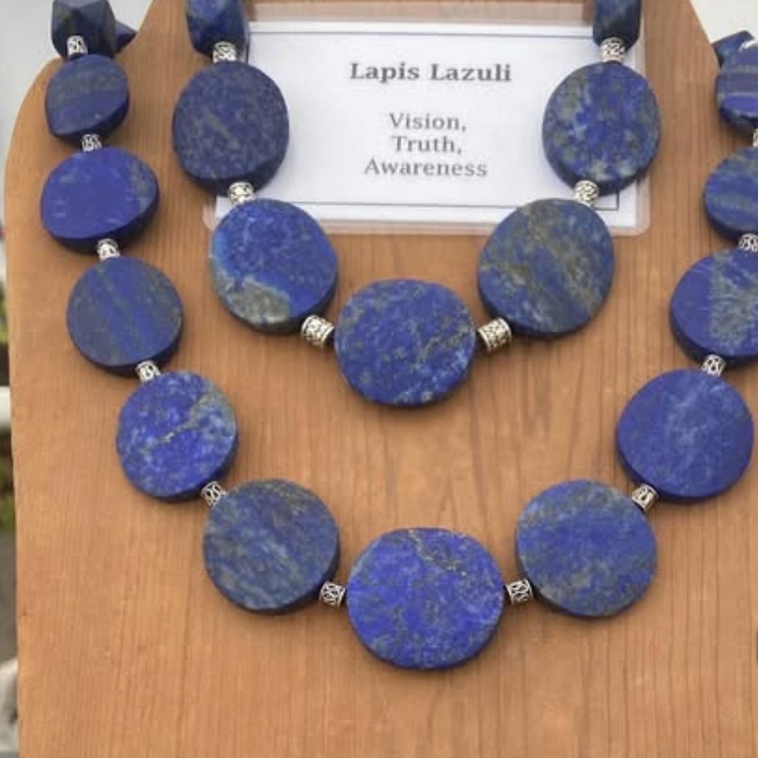 A double-strand necklace of flat lapis lazuli discs in deep blue, separated by small silver beads