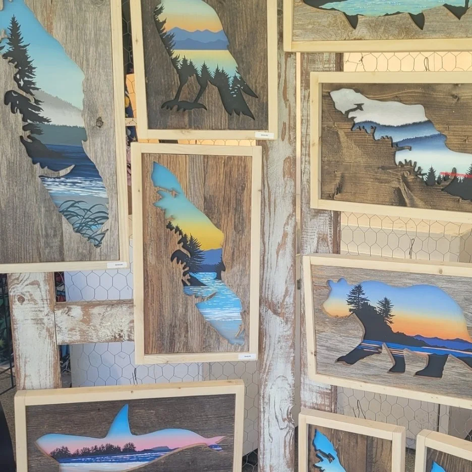 His market display, framed cutouts of islands, bears, ravens, salmon and orcas hung across a weathered barnwood wall
