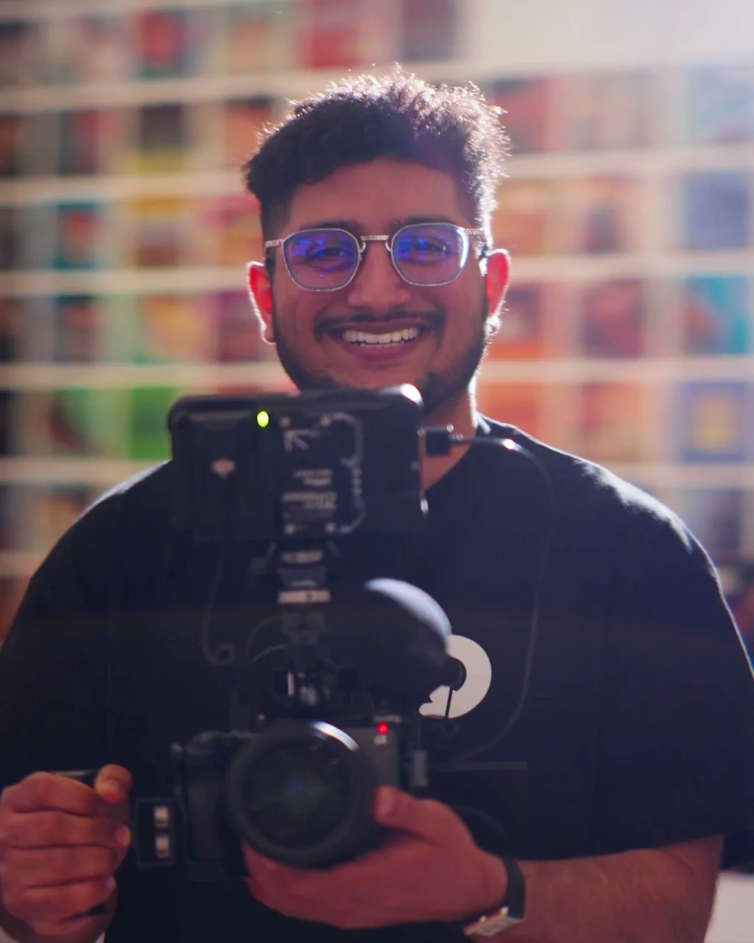 Avi Ratnani smiling behind his cinema camera on a shoot