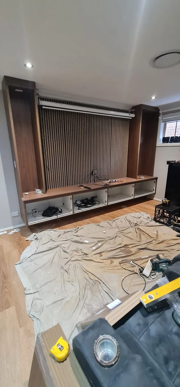 The vertical slatted panel being fitted behind the television position