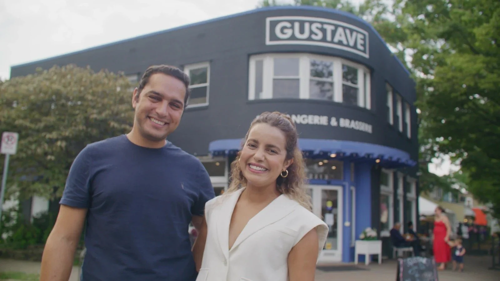 Two people smile outside Gustave, a neighborhood bakery and café in Del Ray.