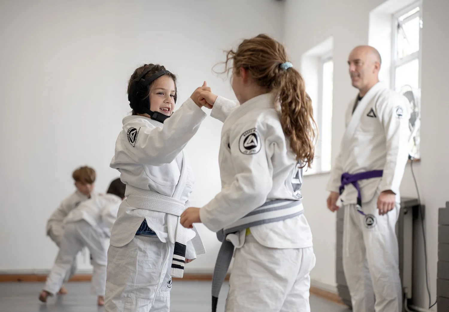 Children enjoying a partner drill with an instructor watching at RGA South Herts