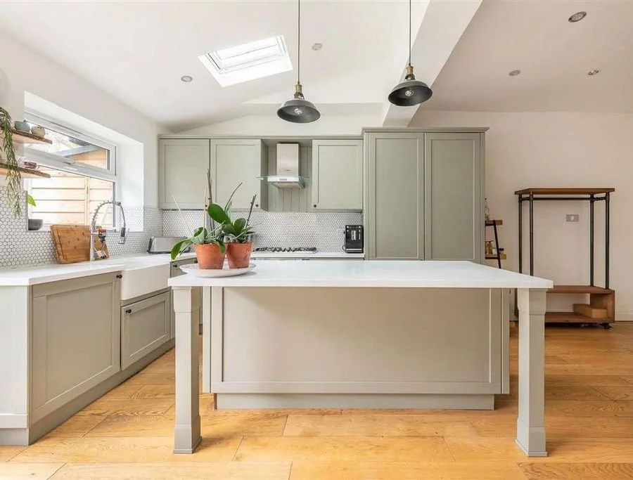 After: the new kitchen with island and sage cabinetry