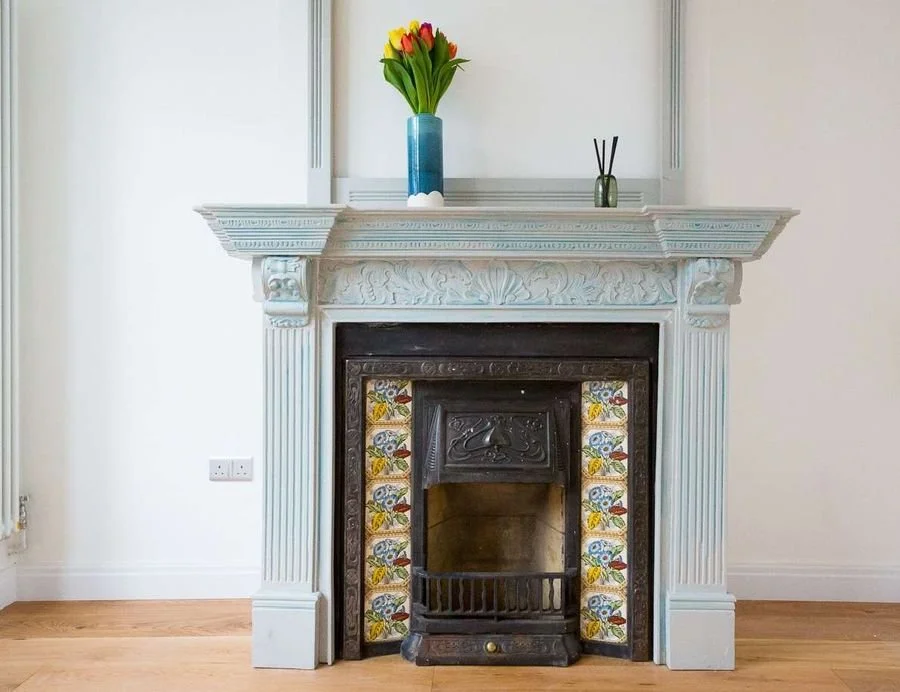 After: the restored fireplace with duck-egg surround and original tiles