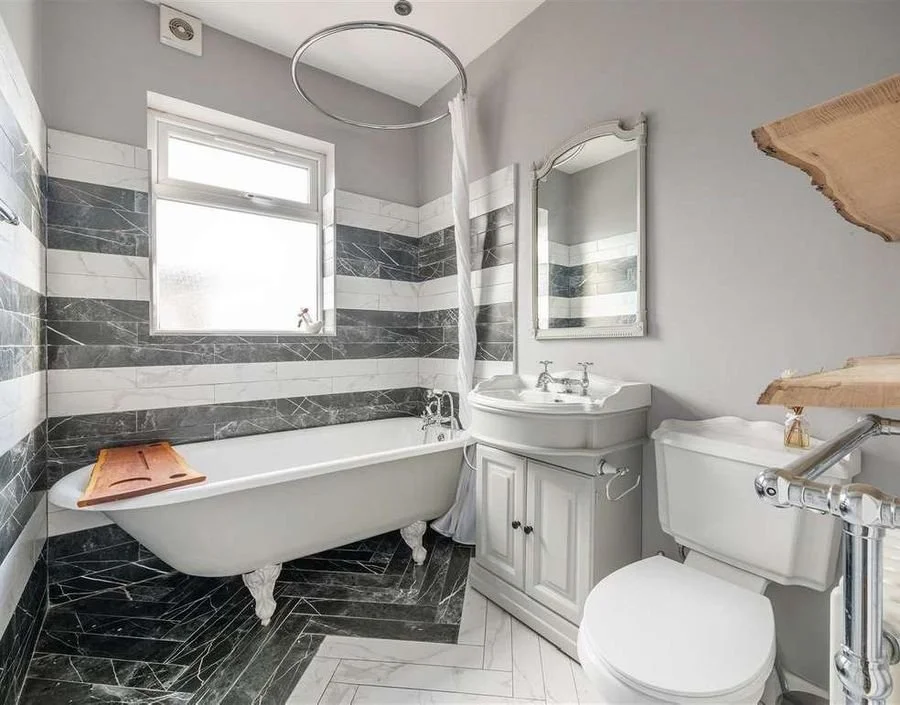 After: the family bathroom with marble-striped walls and clawfoot bath