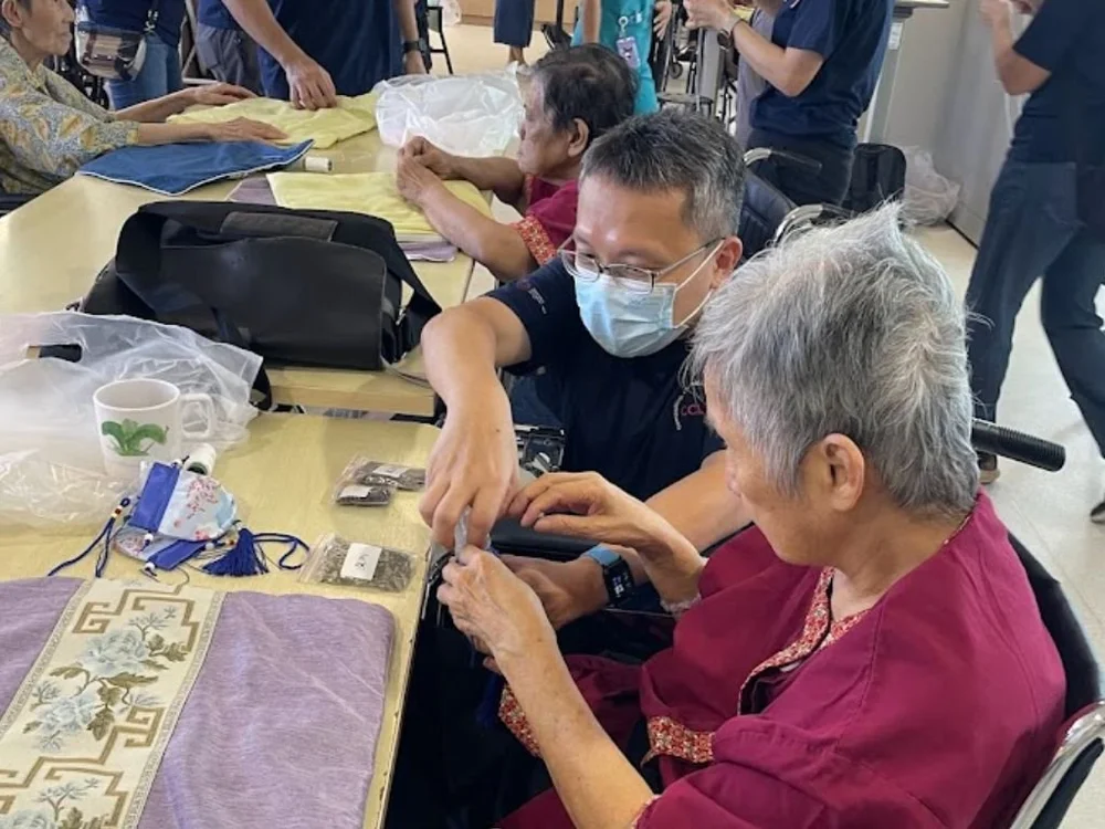 Corporate volunteer supporting a senior during a hands-on CSR activity in Singapore