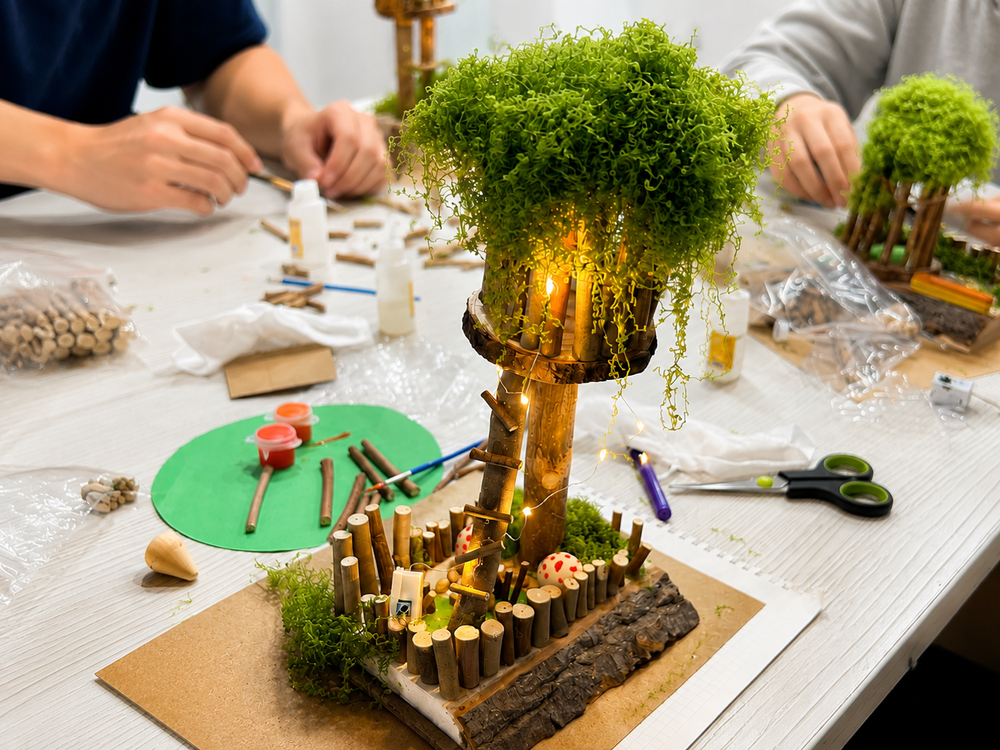 Nature-inspired treehouse craft model made with wood, moss and lights during a hands-on art workshop