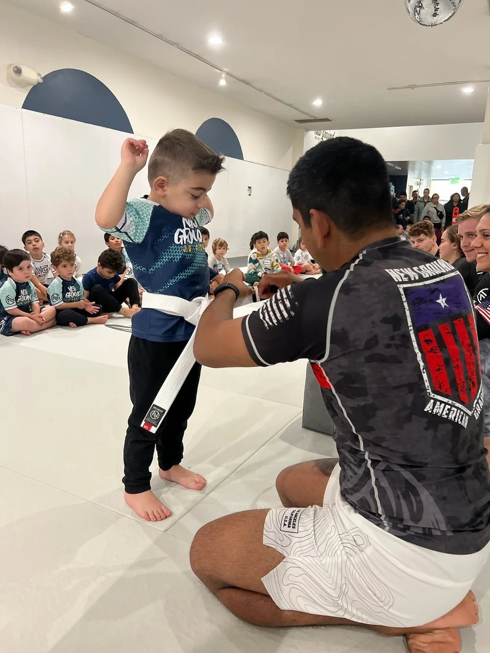 A young student being awarded a stripe in front of the class
