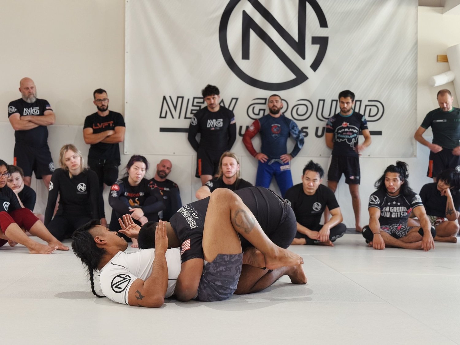 Members gathered around a coach demonstrating a technique