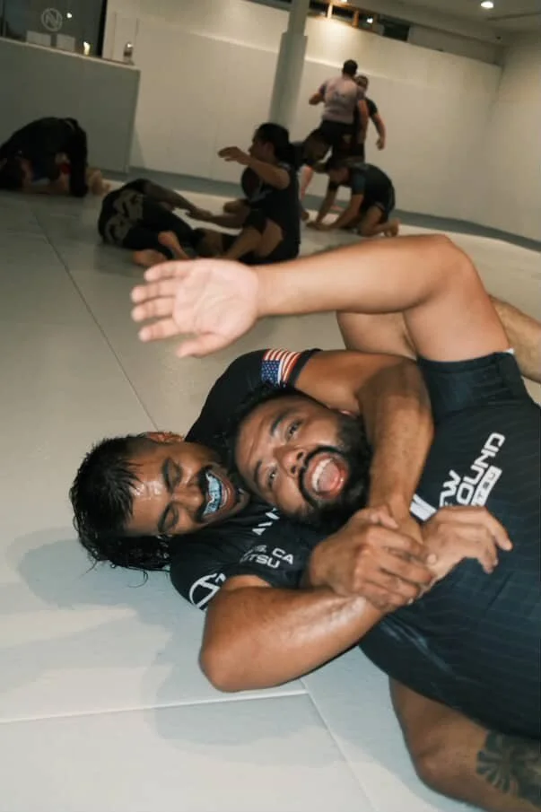Two training partners laughing mid-roll