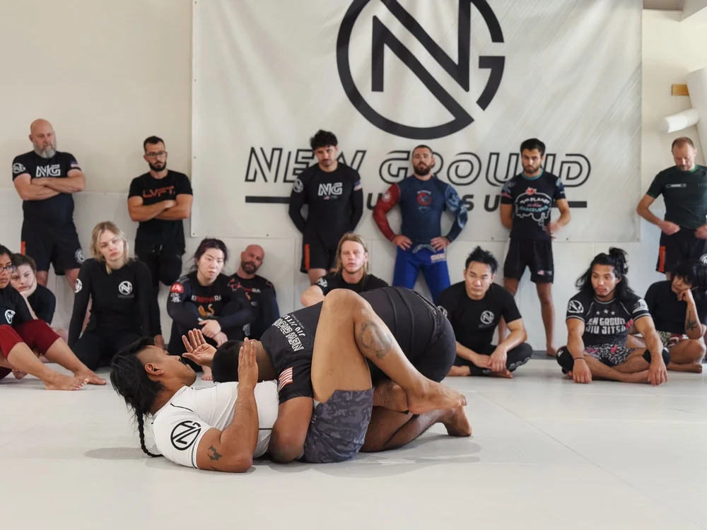 The whole class gathered around a coach demonstrating a technique