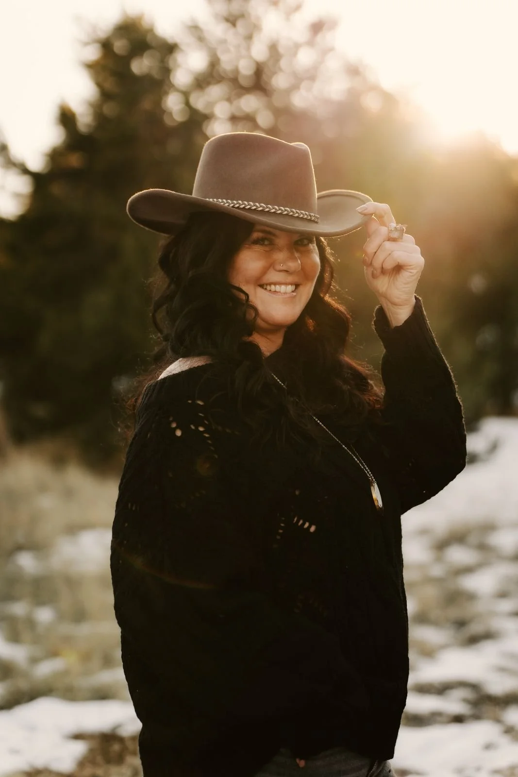 Raechelle smiling, tipping her hat