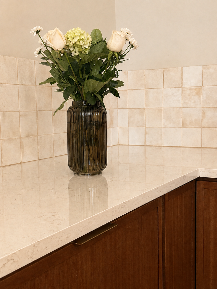 Kitchen detail with warm wood cabinetry, pale tile backsplash and stone countertop