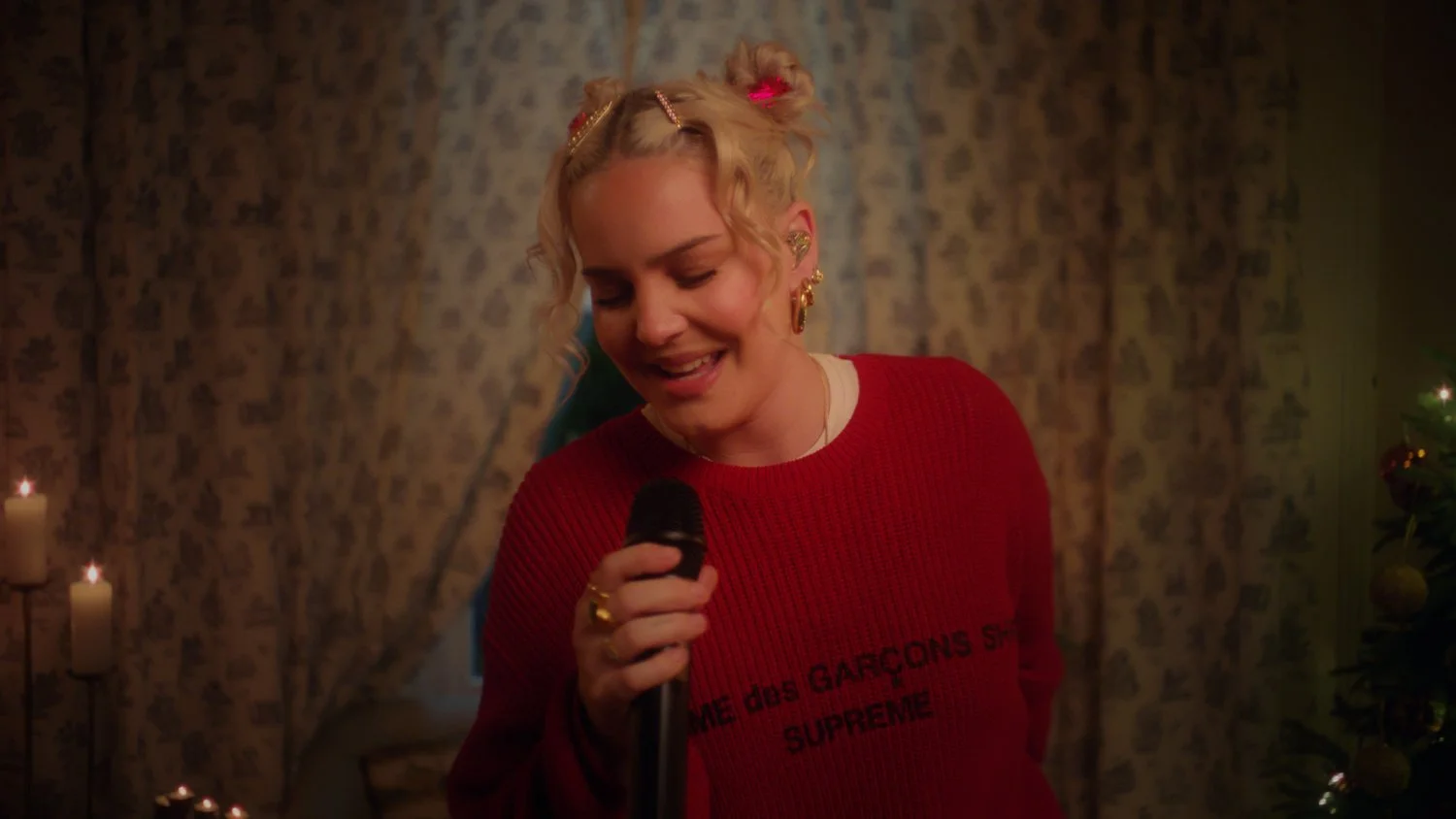 Anne Marie performing in a warmly lit room, from Wild Christmas