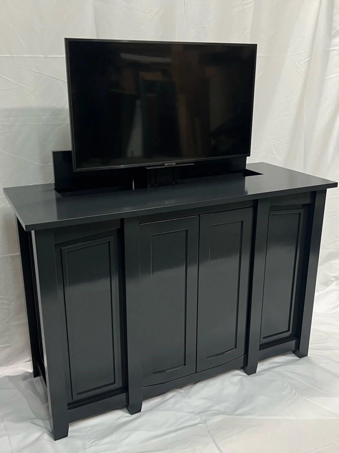 Custom TV lift table with hidden screen raised above the cabinet