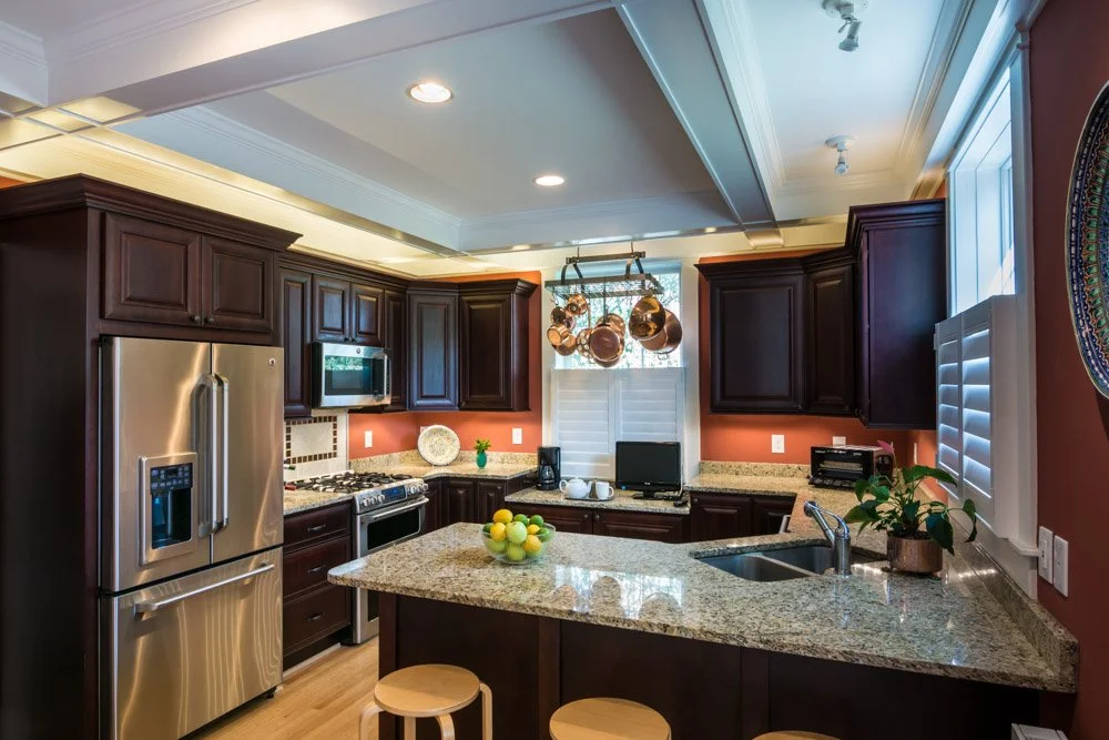 Finished kitchen with coordinated counters, tile, lighting, and cabinetry