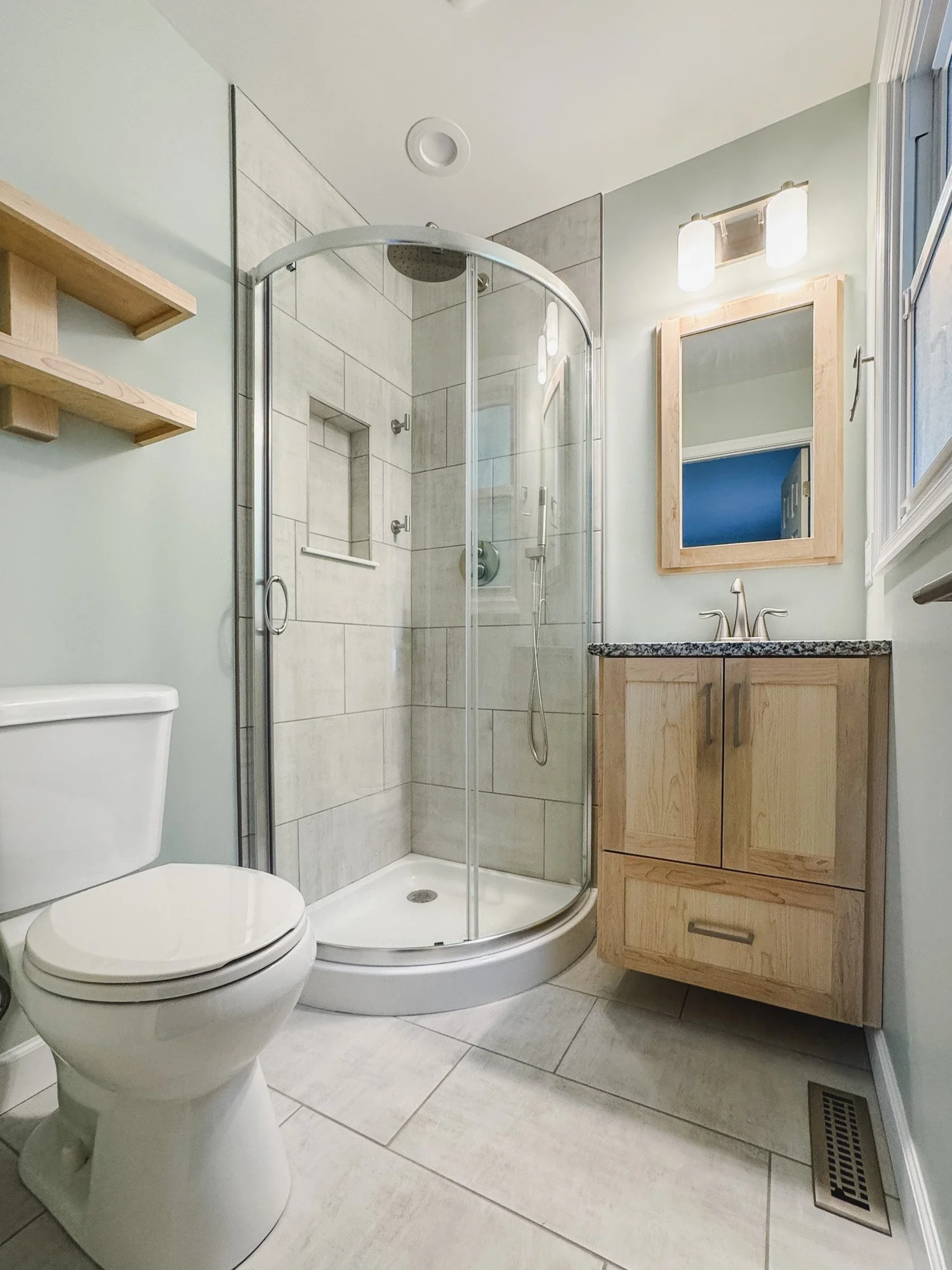 Bathroom vanity, mirror, lighting, and storage details