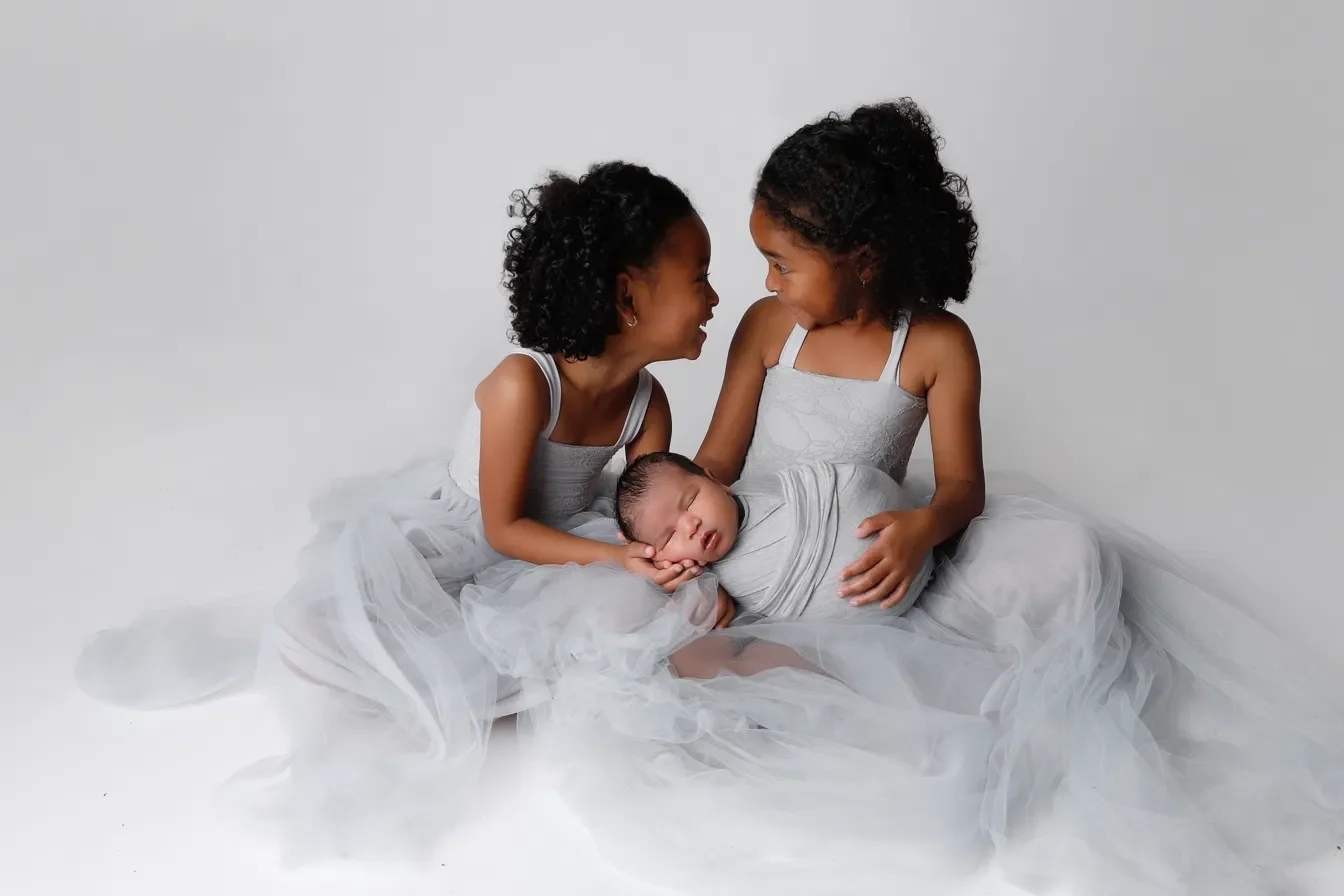 Newborn photographed with an older sibling