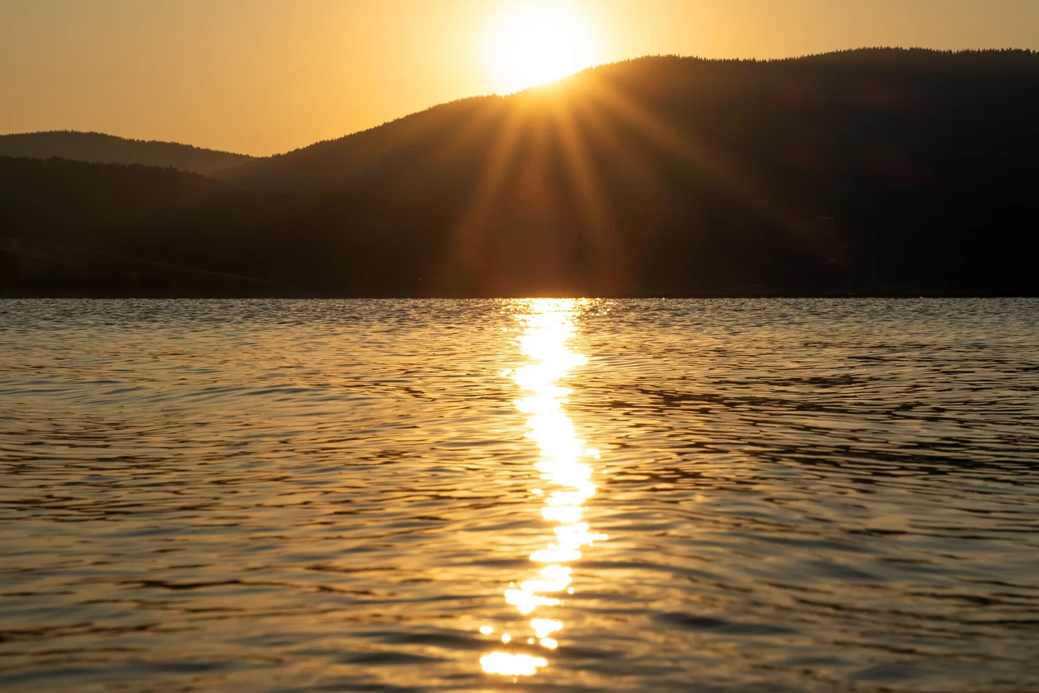 Sunrise over open water, light spreading across the surface