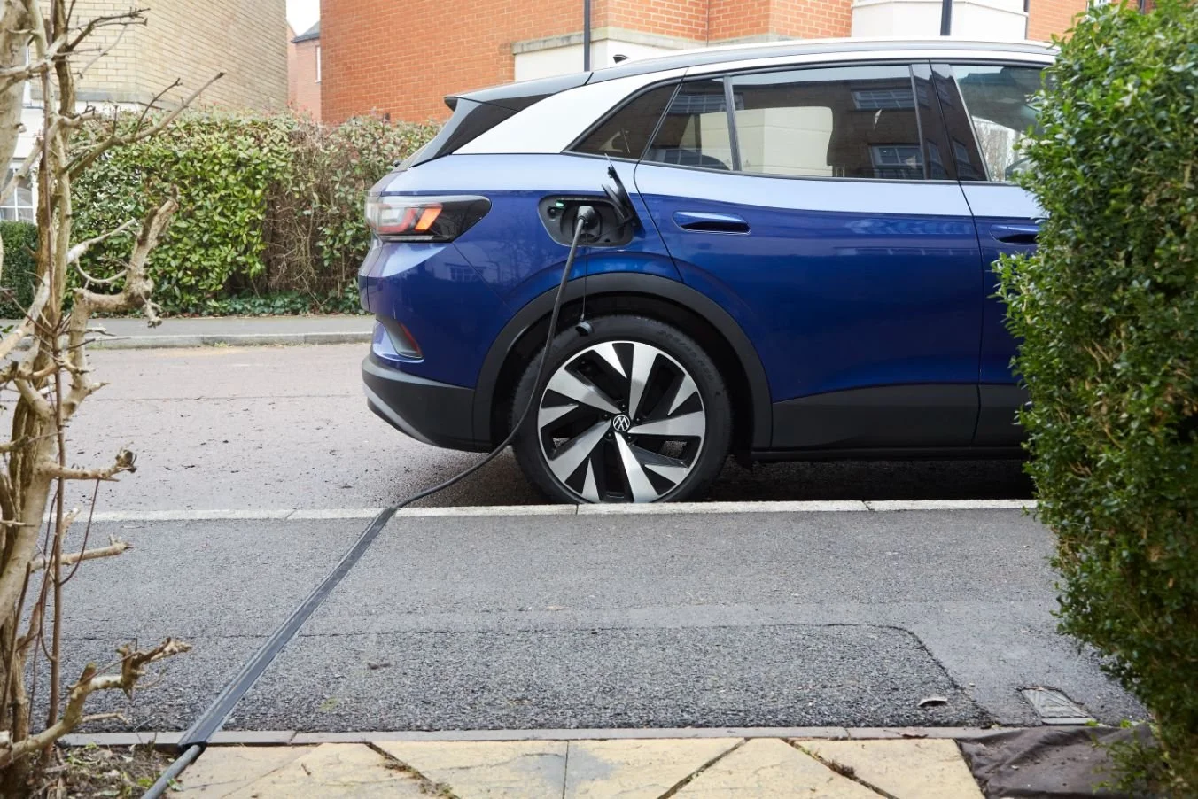 EV cable running through a Kerbo Charge pavement channel to a car on the street