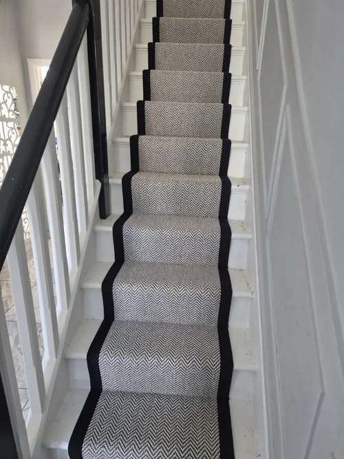 Grey herringbone stair runner with a dark border