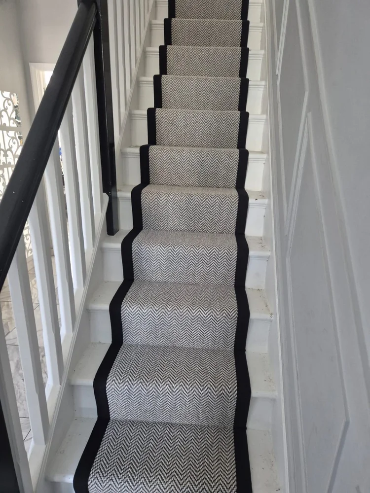 Grey herringbone stair runner with a dark border