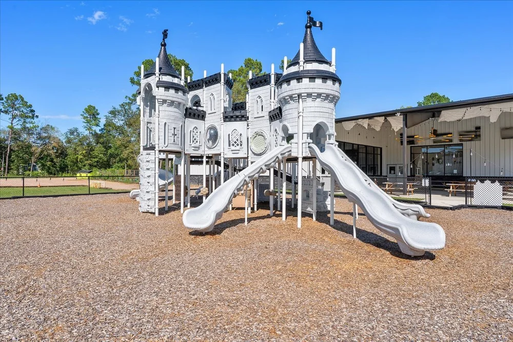Black and white castle-themed playground with twin slides