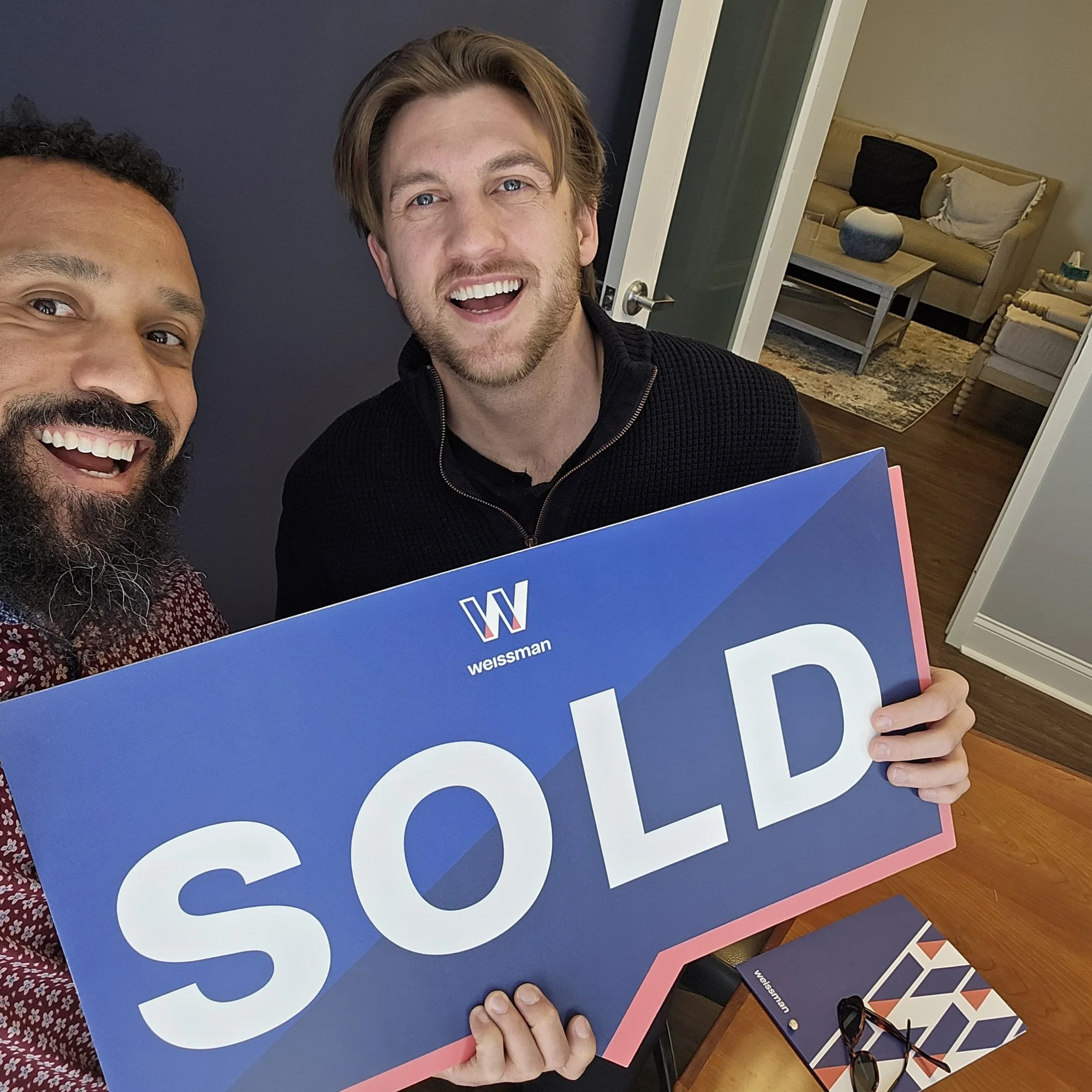 A client and our team beside the sold sign