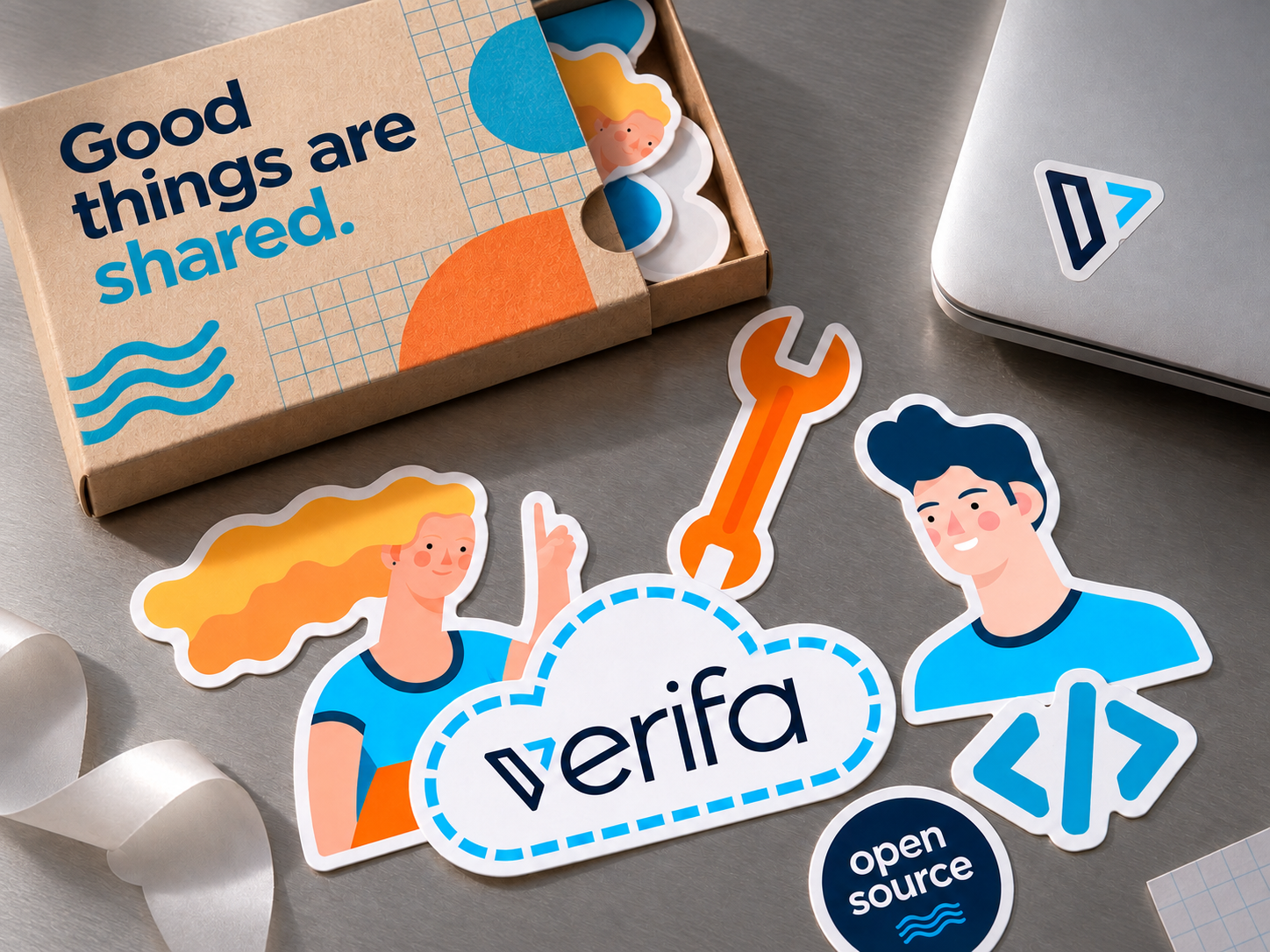 Verifa sticker collection concept with the original cloud wordmark, illustrated people, orange wrench and kraft packaging on a metal workbench