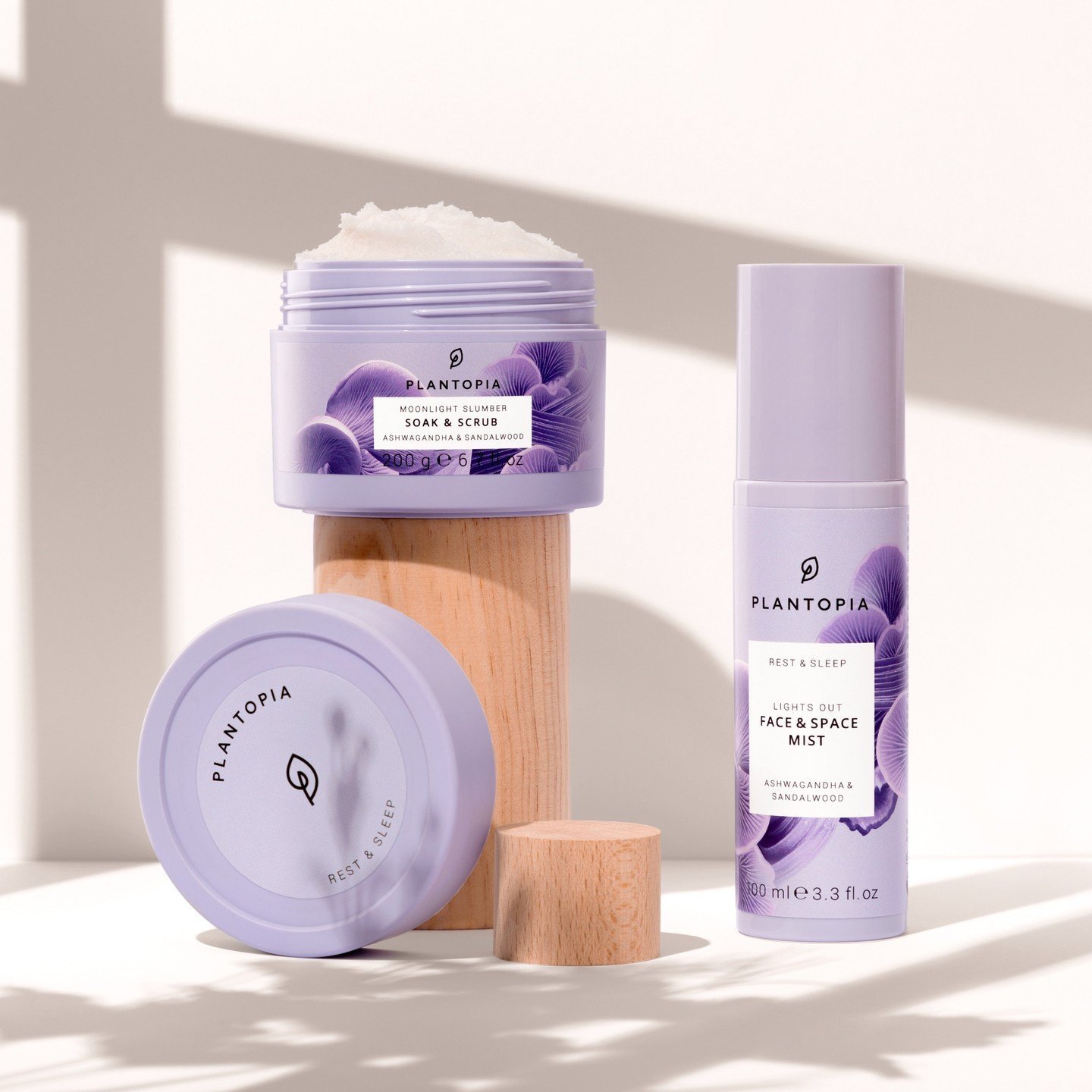 Existing Plantopia Rest & Sleep product photograph: lavender Soak & Scrub jar and Face & Space Mist on wooden plinths