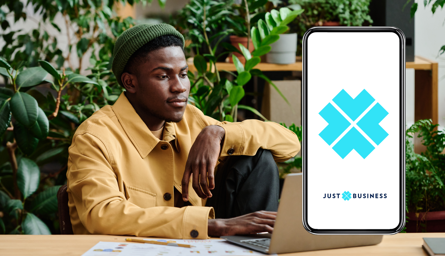 Original Just Business mobile branding beside a founder working among plants