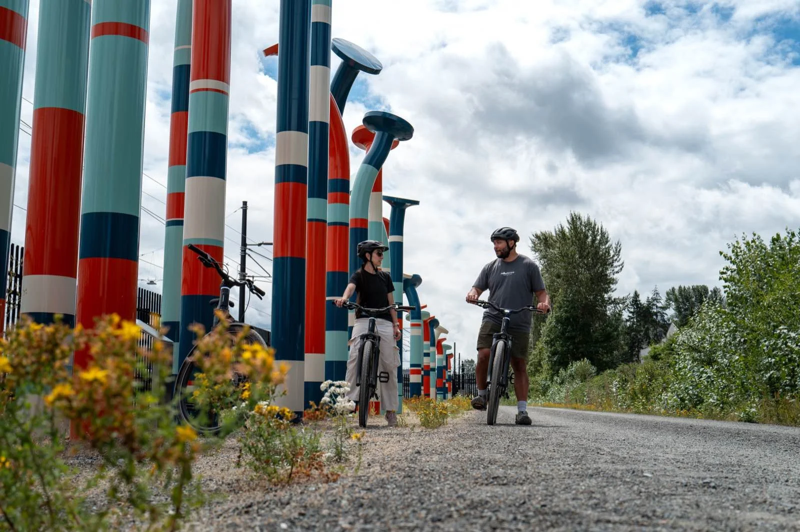 Riders on the Eastrail passing the tall striped art pillars