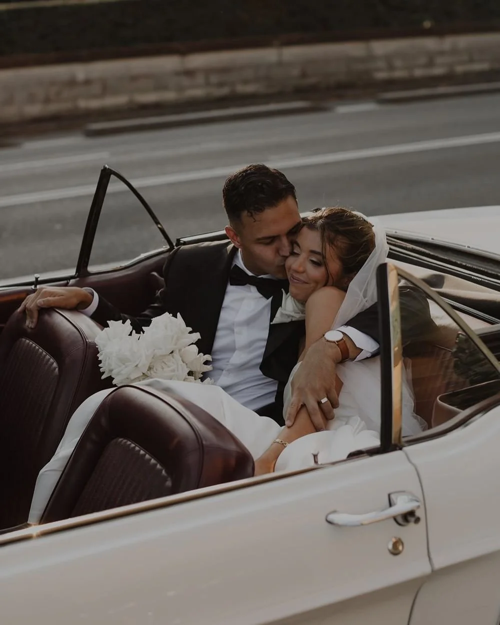 Bride and groom in a vintage convertible