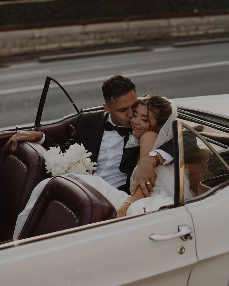 Bride and groom in a vintage convertible