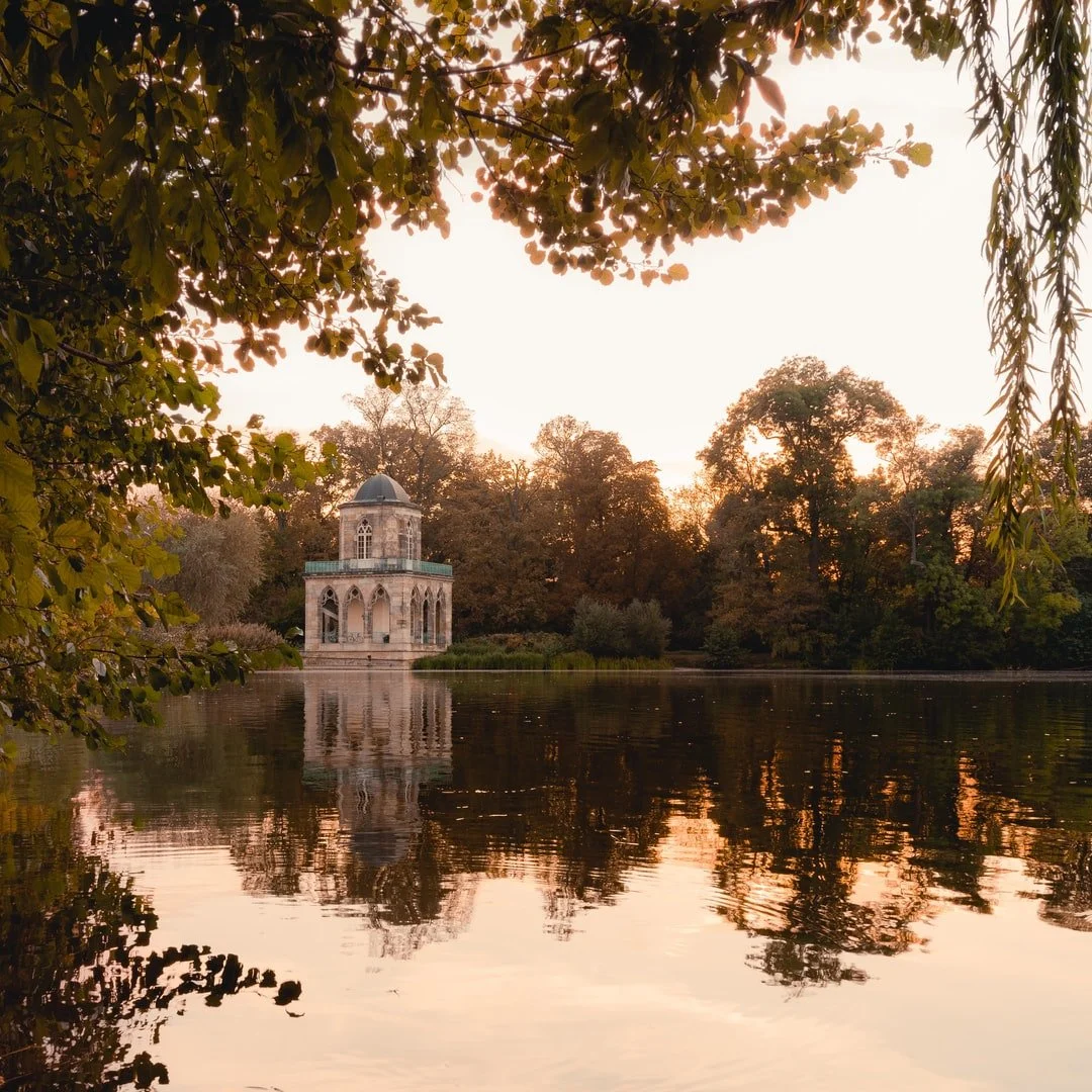 A lakeside pavilion reflected in calm water