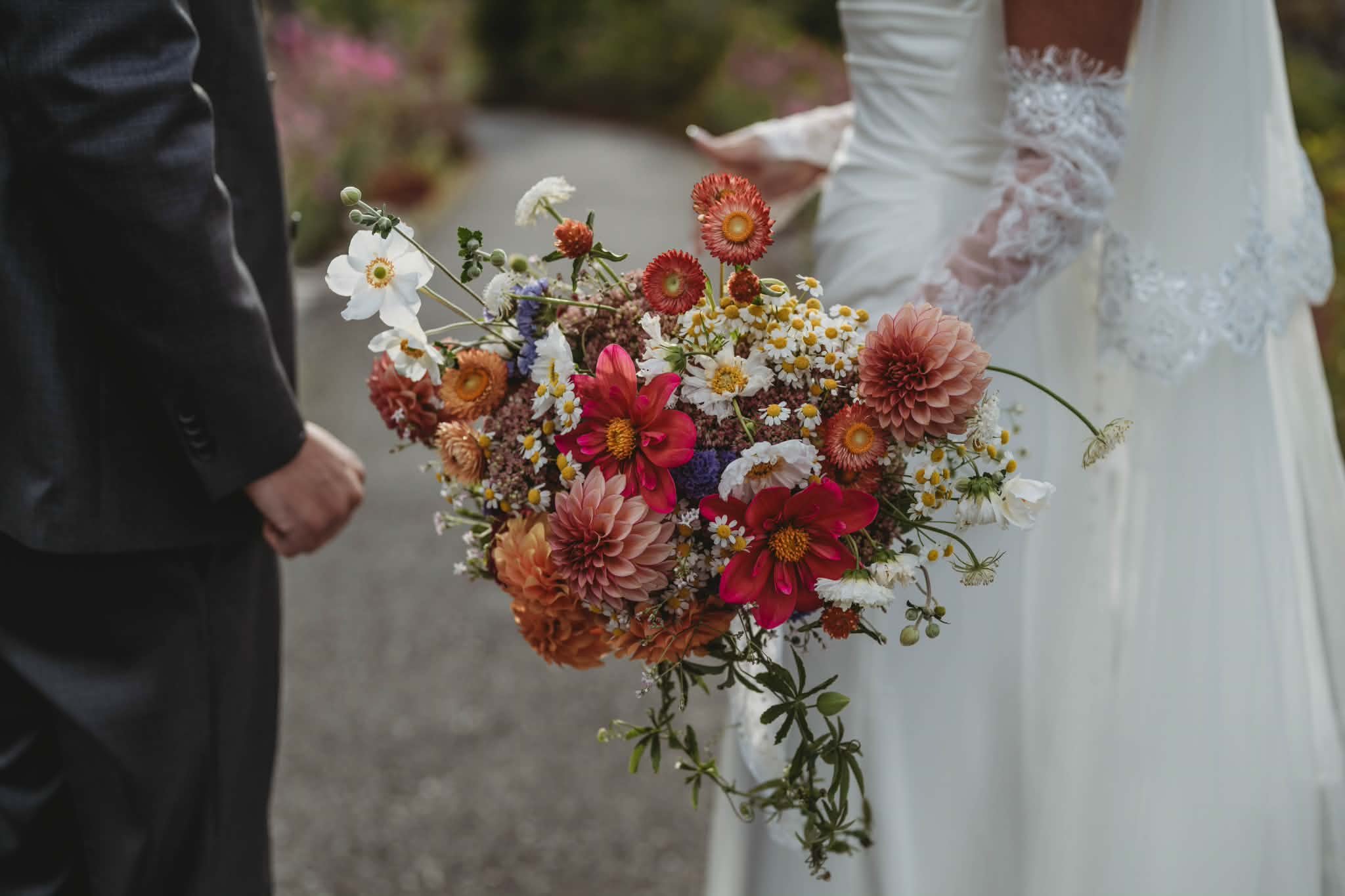 Bride holding a colorful garden-style bouquet with dahlias and seasonal flowers
