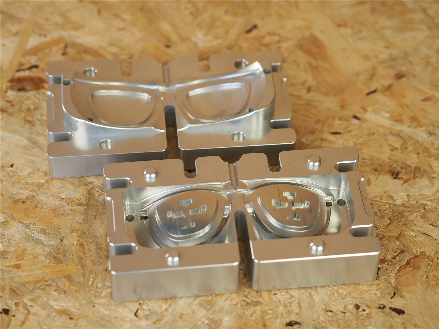 The frame mould open in two halves on a workbench, both cavities clean and empty before a run