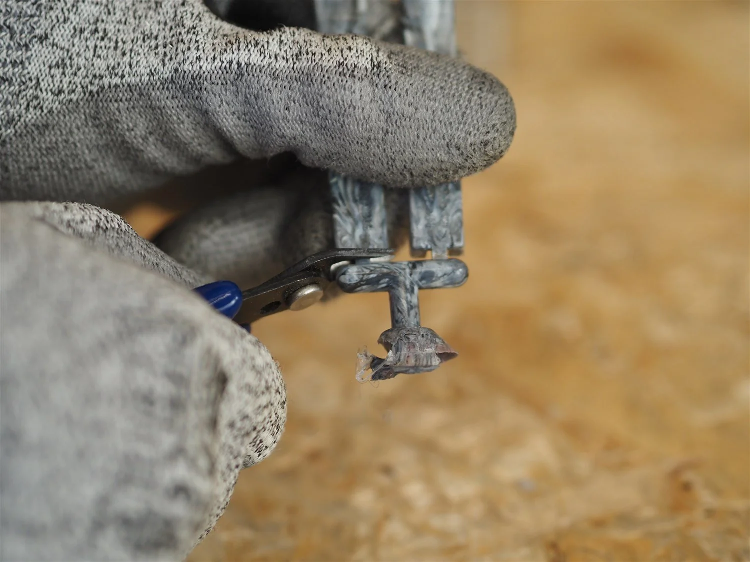 Flush cutters separating the moulded arm from its runner and sprue