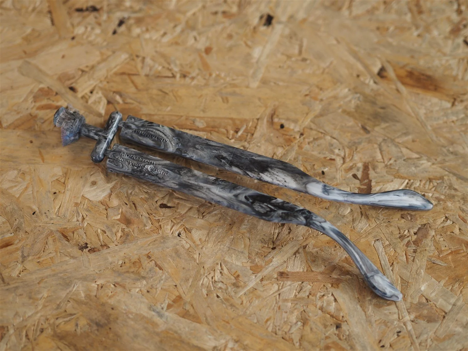 The pair of moulded arms lifted clear of the mould, still joined to each other by the runner and sprue
