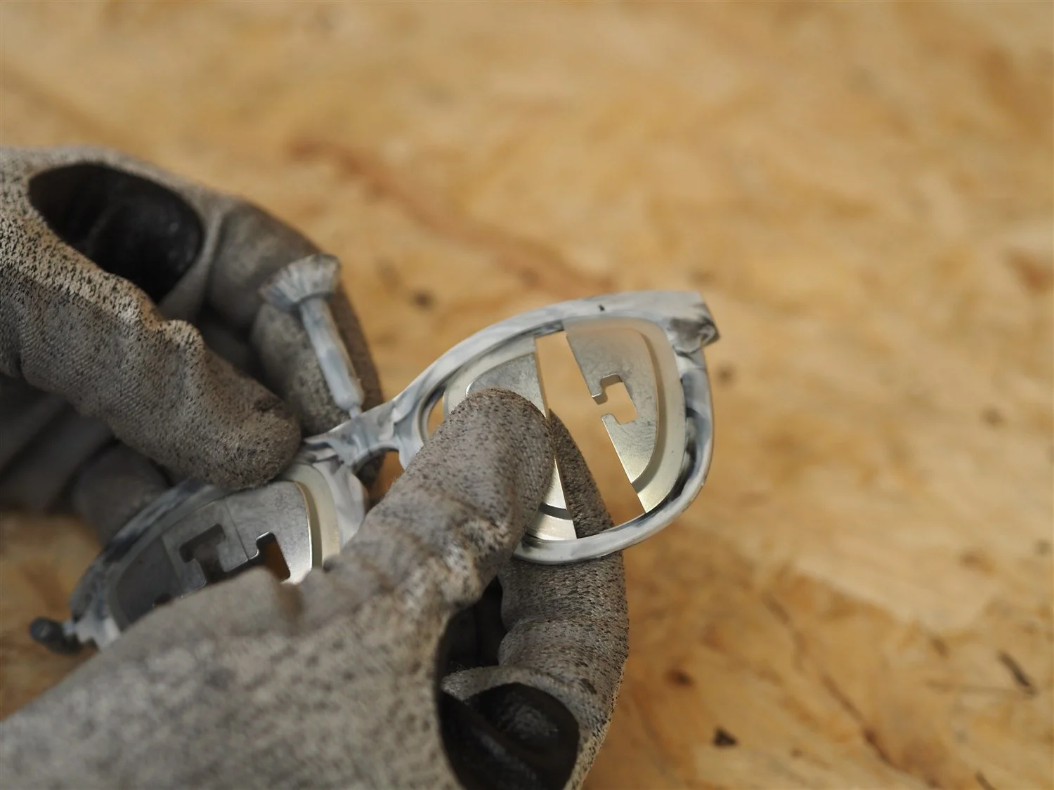 A gloved hand drawing a lens insert out of the moulded frame to release it, the second insert still in place