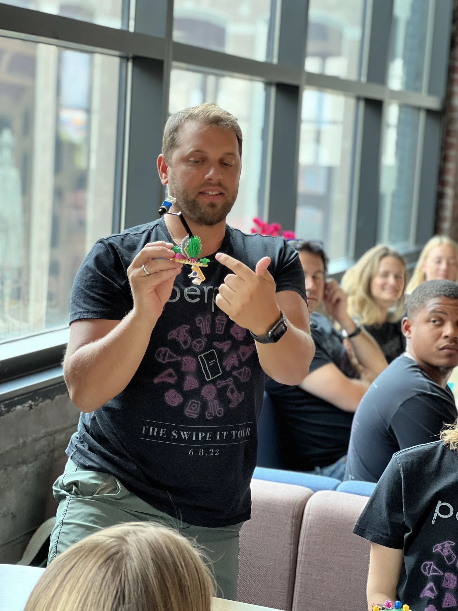 A leader holding up his LEGO model and explaining it to the group