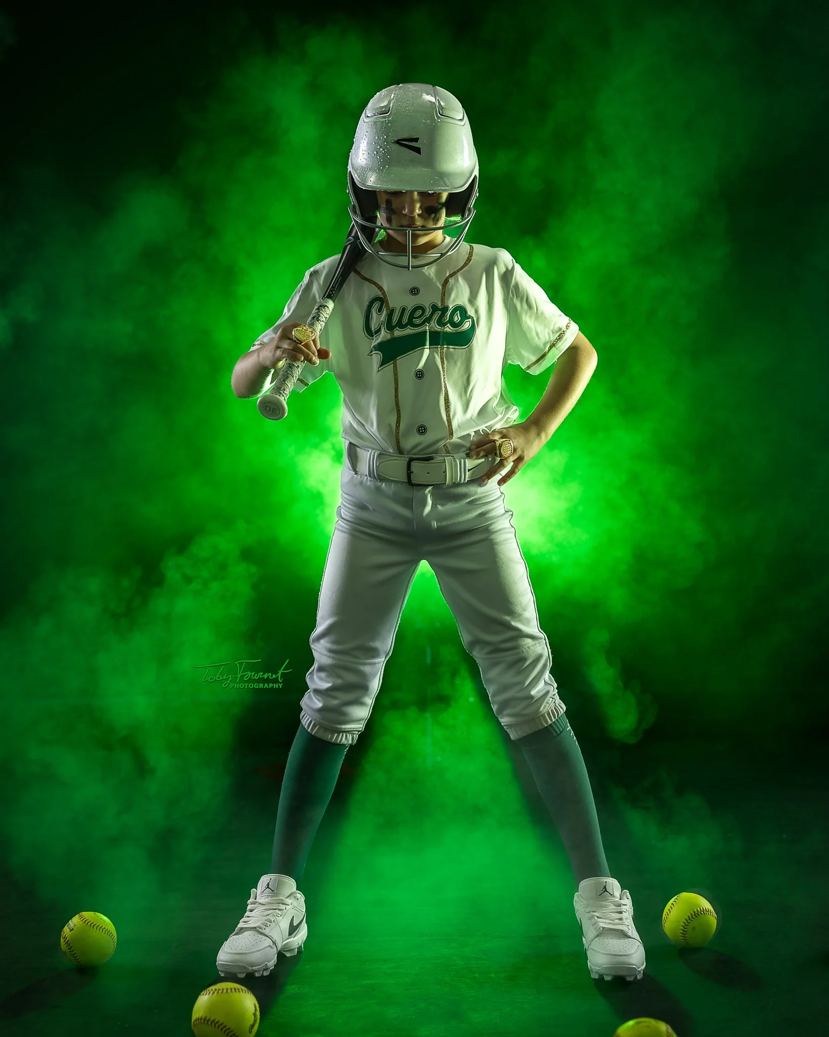Softball athlete with a bat against green lighting