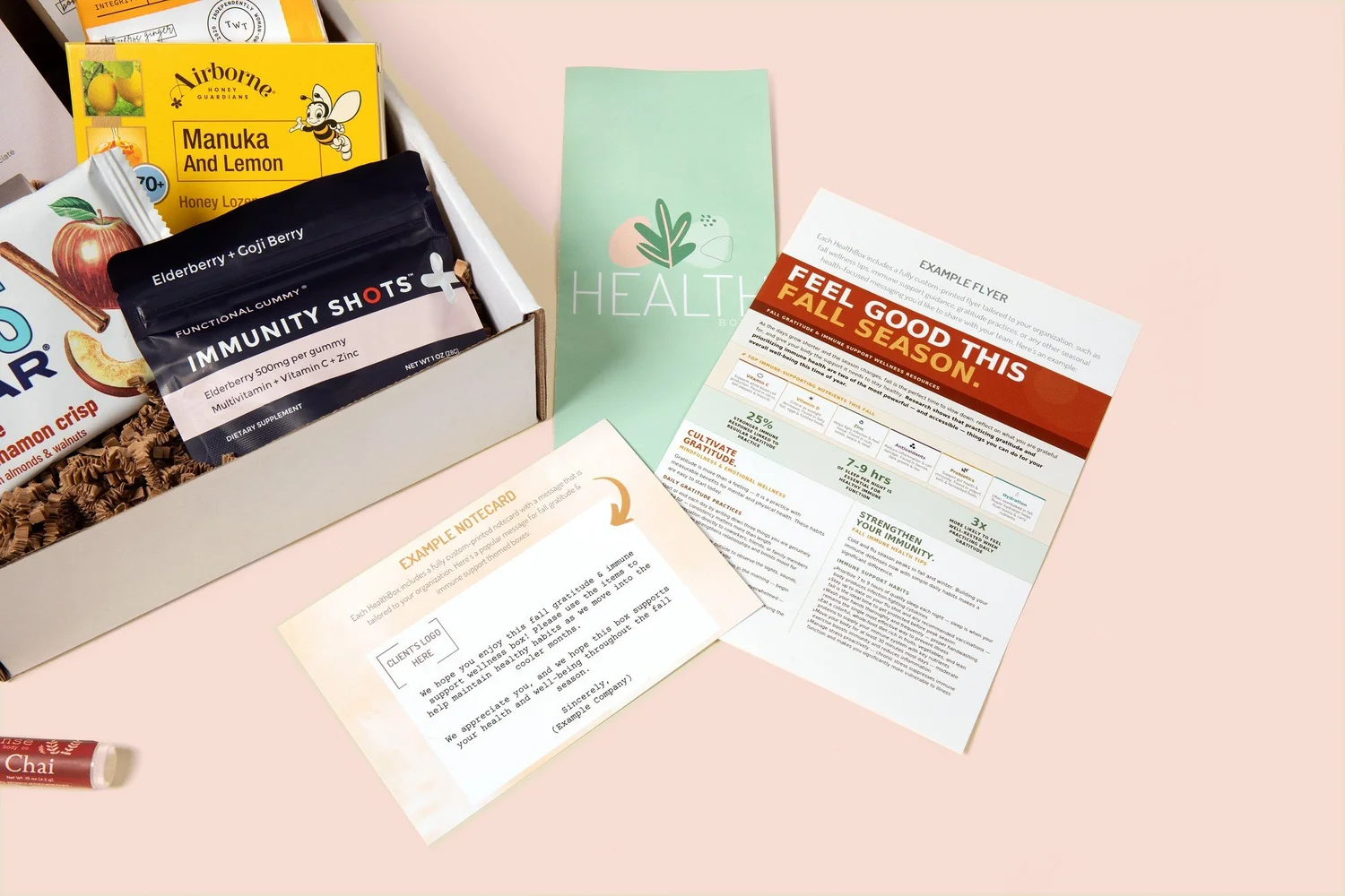 A custom printed wellness flyer and HR notecard beside an open HealthBoxed wellness box