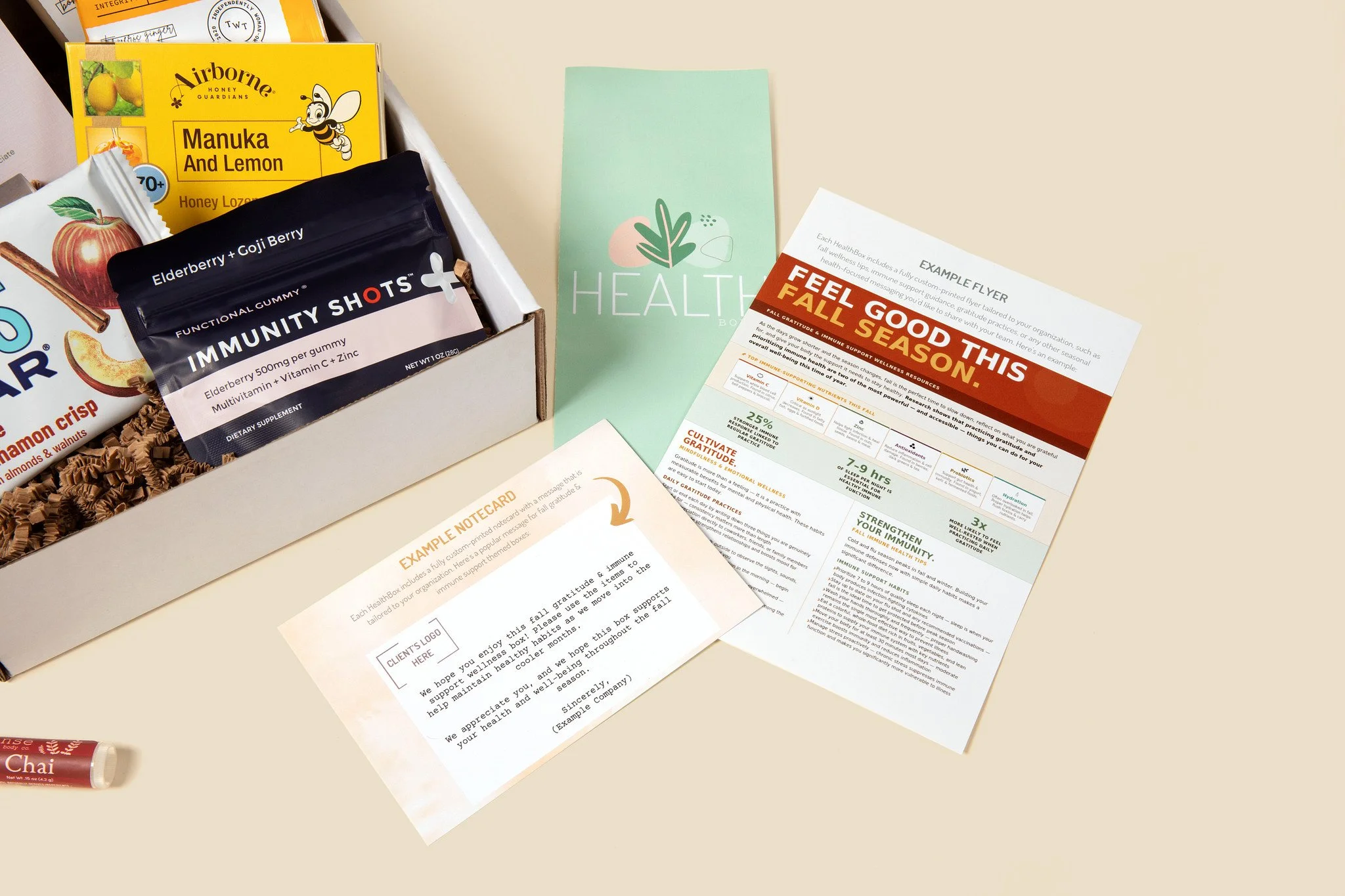 HealthBoxed custom printed inserts: an example notecard with space for the client's logo and an example seasonal wellness flyer, next to a wellness box