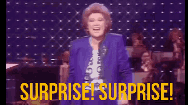 A white woman in a purple 80s jacket sings SURPRISE