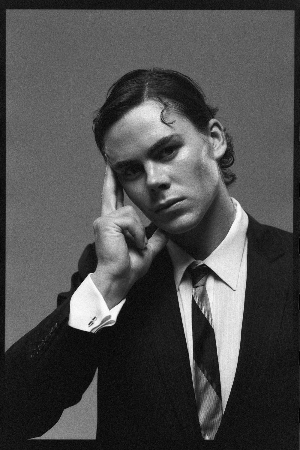 Dancer resting his head on his hand, looking to camera